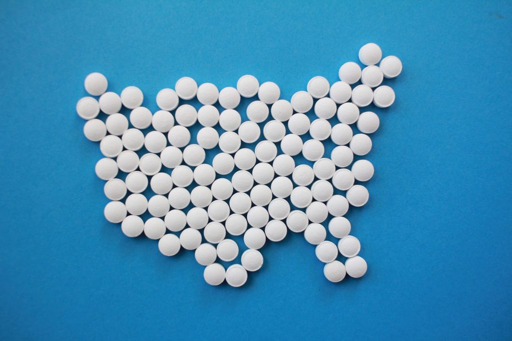 White aspirin tablets laid out on a blue table