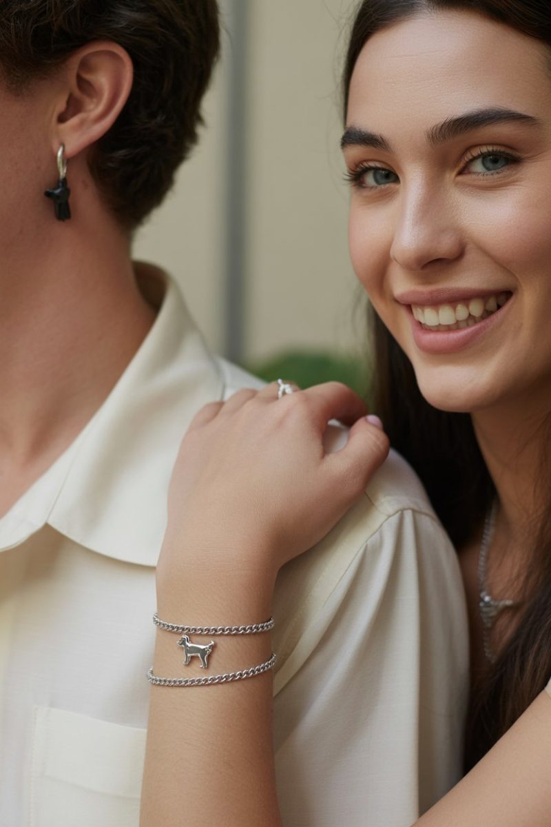 The image shows a young woman wearing delicate silver jewelry including a thin chain bracelet with a small dog charm.