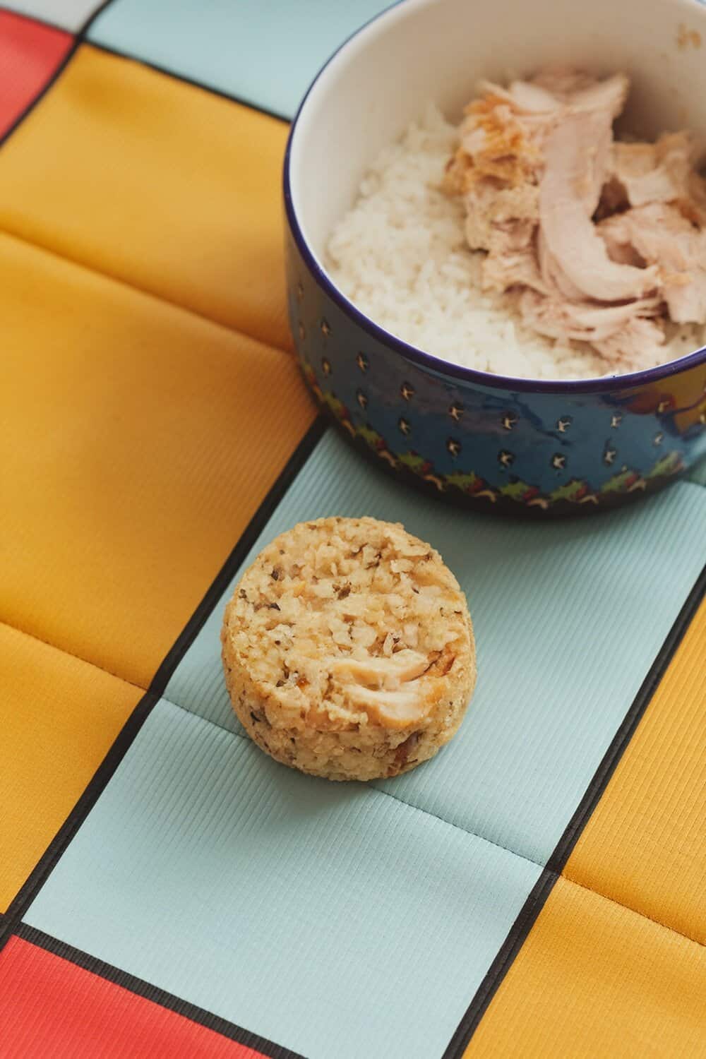 Homemade chicken and rice dog treat next to a bowl of chicken and rice.