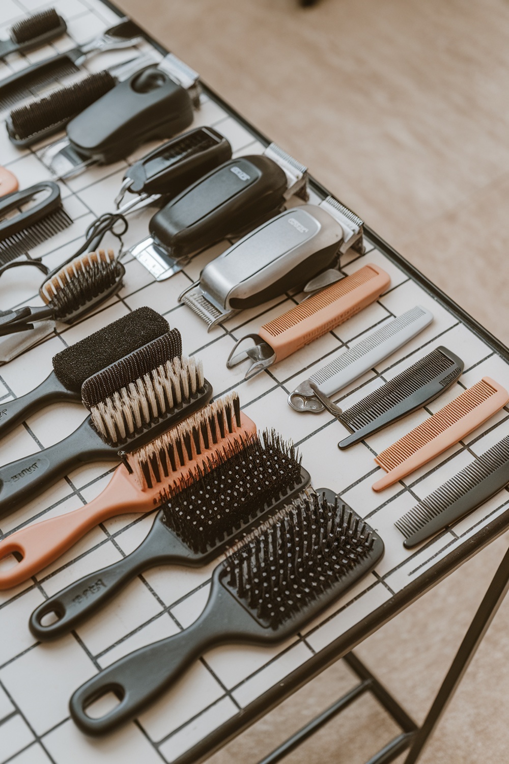 A variety of grooming tools including brushes and clippers laid out on a table.