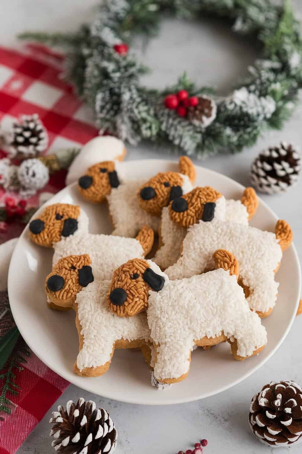 A plate of dog-shaped coconut and rice cookies decorated with chocolate and coconut.